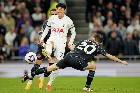 Son Heung-min and Bernardo Silva challenge for the ball